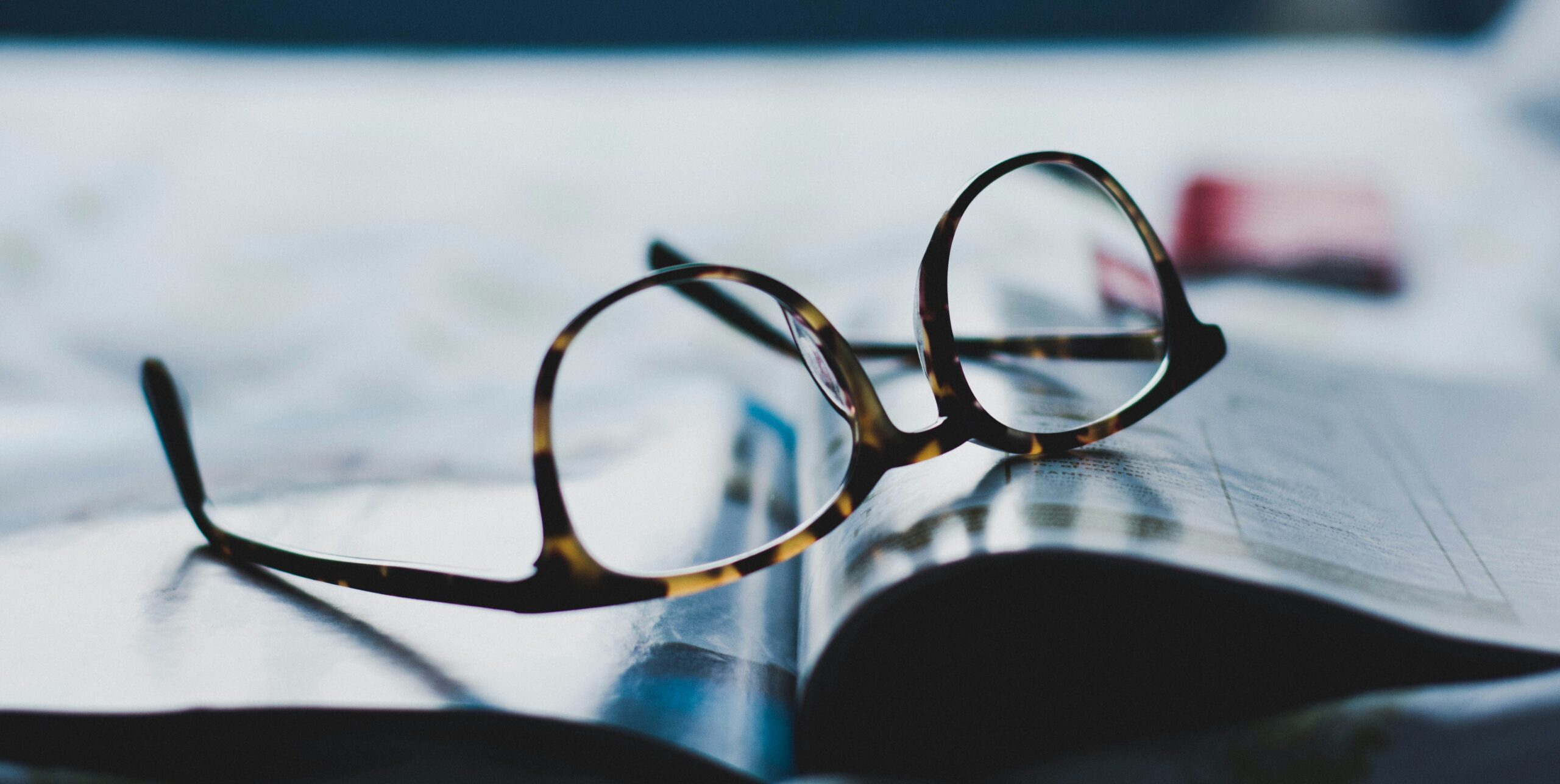 Glasses sit on top of a newspaper