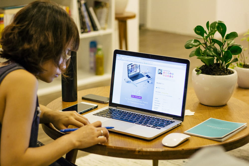 Woman sat on laptop at desk, working on her SaaS accounting.